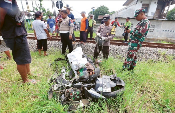 Polisi memeriksa motor yang tertabrak kereta api di dekat perlintasan sebidang Jalan Soneta, RT 62/RW 13, Dusun Sonotengah, Kebonagung, Kecamatan Pakisaji, kemarin (24/11).