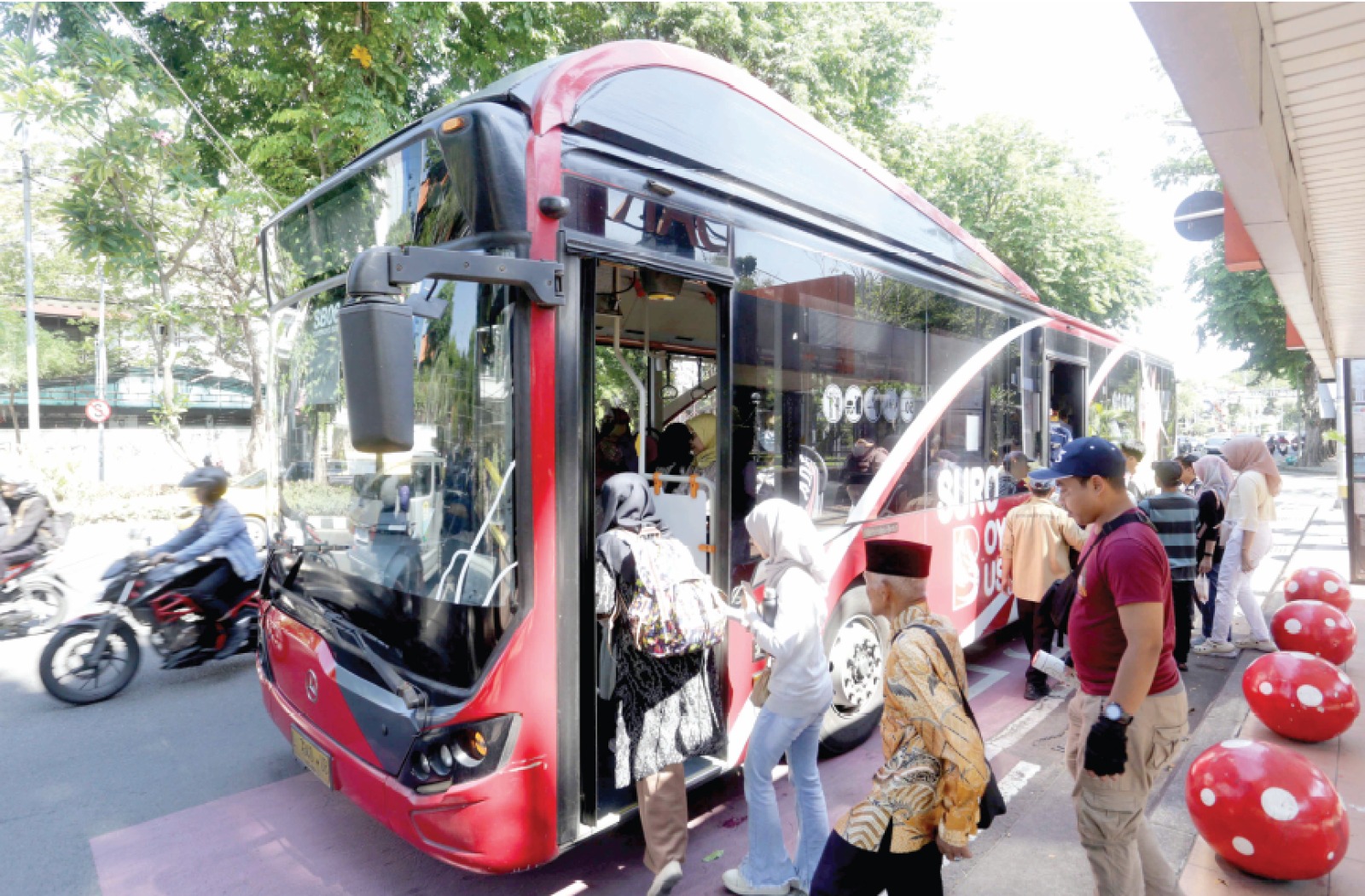 TRANSPORTASI PUBLIK: Sejumlah penumpang antre untuk naik Suroboyo Bus kemarin siang.
