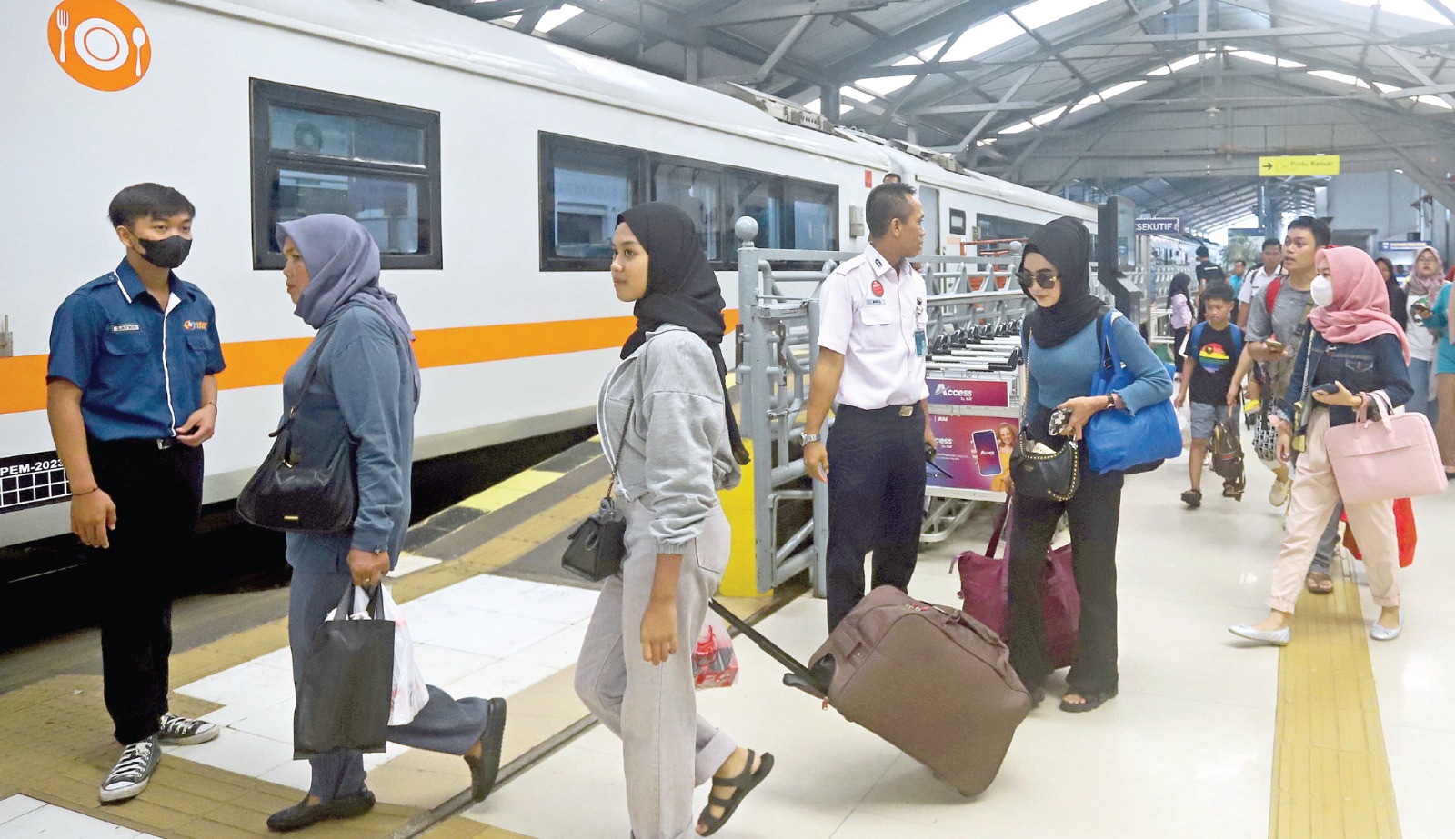 RAMAI LANCAR: Para penumpang di Stasiun Pasar Turi berajalan menuju kereta api yang segera berangkat kemarin siang.
