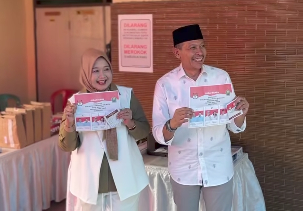 Calon Walikota Wahyu Hidayat (kanan) dan istri, nyoblos di Pilkada Kota Malang 2024. Hasil quick count dengan sampel 97.5 persen, Wahyu menang