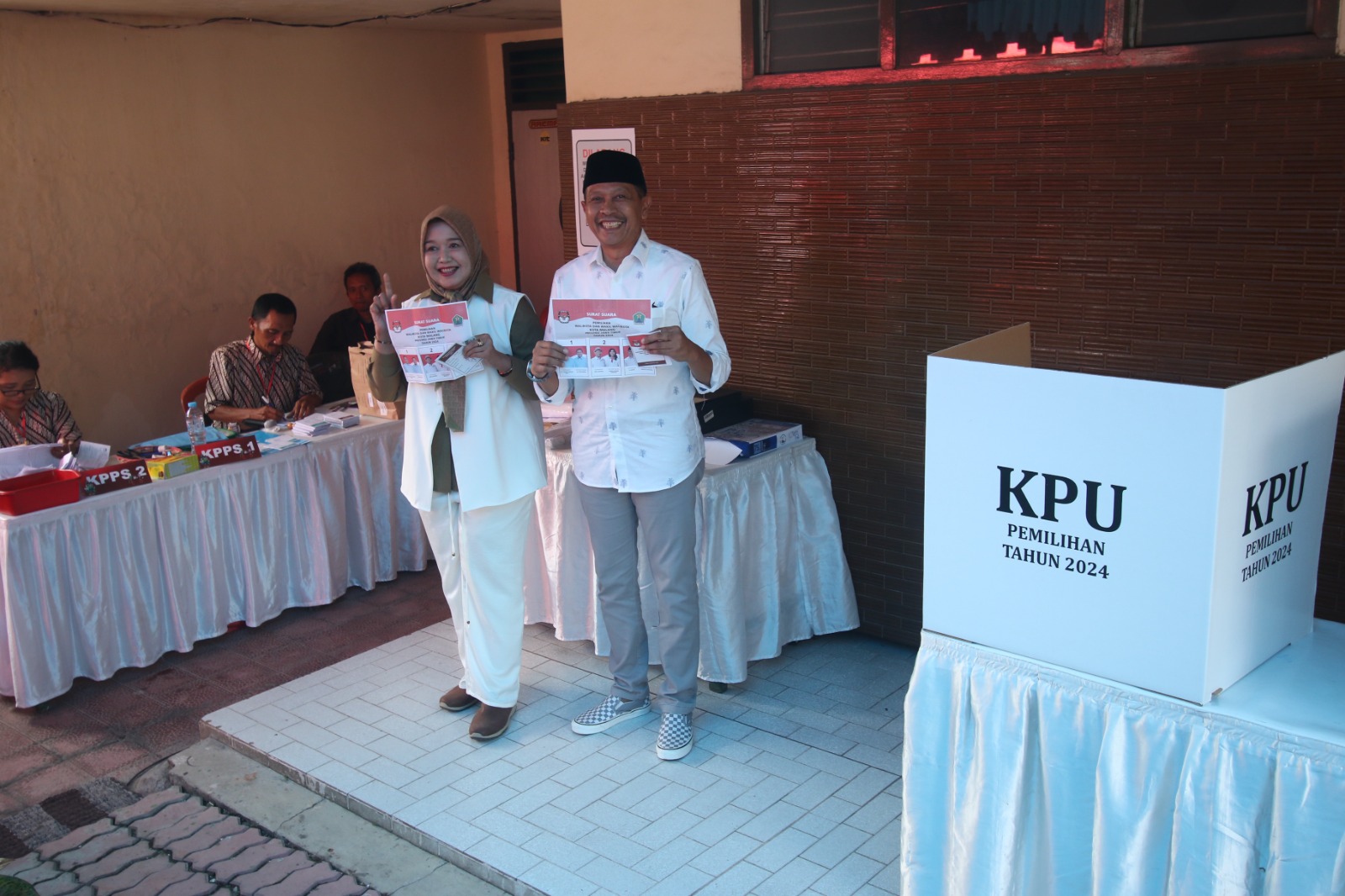 OPTIMISTIS: Wahyu Hidayat bersama istrinya, Hanik Andriani Hidayat menyalurkan hak pilih di TPS 20 Kelurahan Jatimulyo, Lowokwaru. SATRIA CAHYONO/ RADAR MALANG