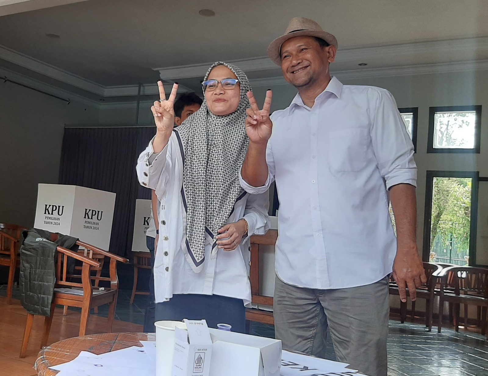 TERIMA SEMUA HASIL: Heri Cahyono didampingi istrinya, Diana, nyoblos di TPS 12 Kelurahan Tunggulwulung, Kecamatan Lowokwaru. DUROTUL KARIMAH/ RADAR MALANG