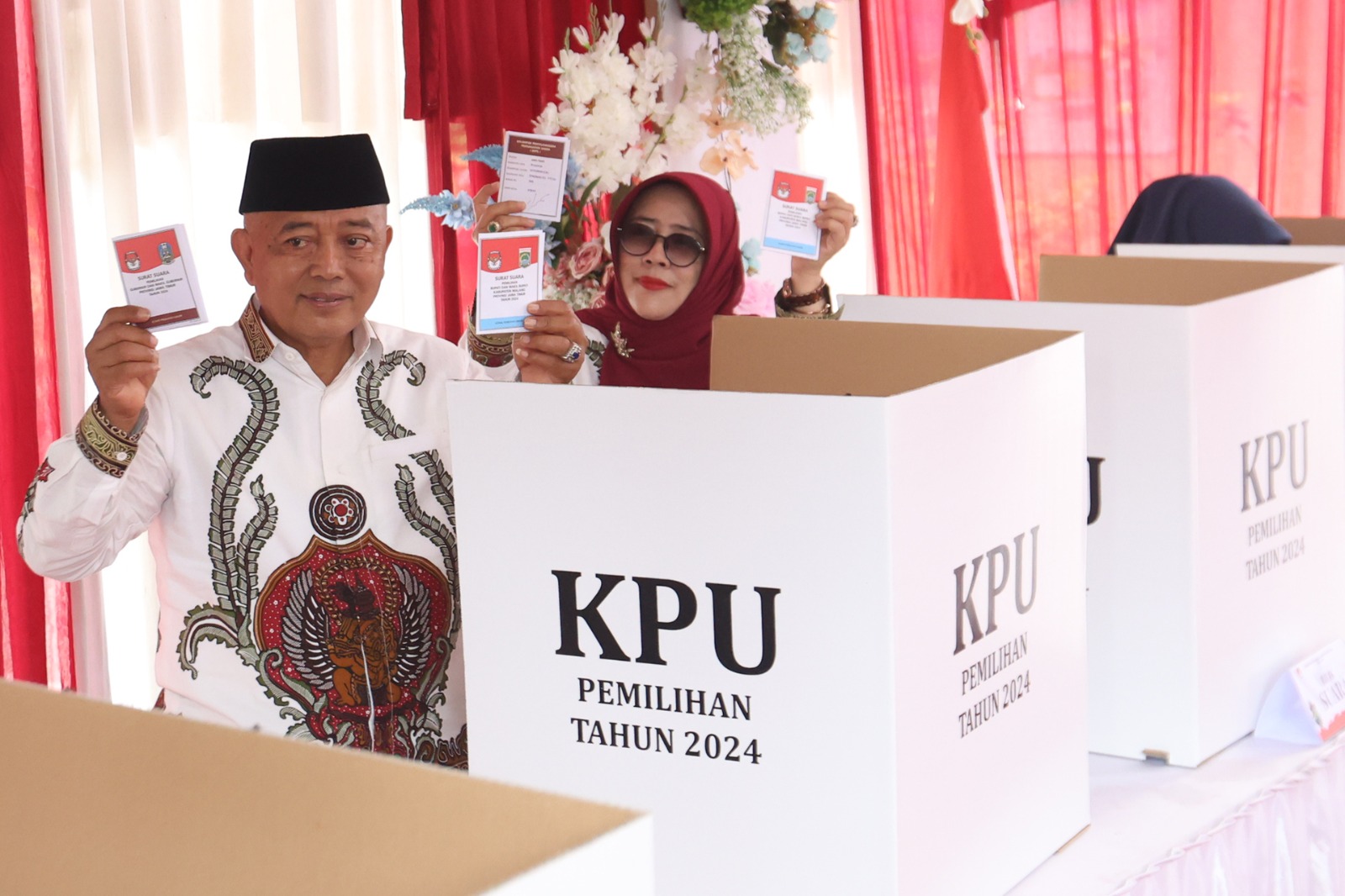 DAMAI: Sanusi dan istrinya menunjukkan surat suara yang sudah mereka coblos di TPS 008 Desa Gondanglegi Kulon kemarin. DARMONO/RADAR MALANG