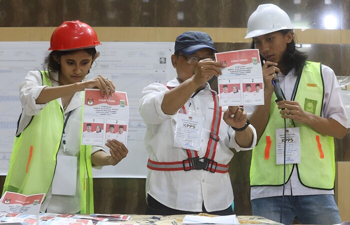 FILOSOFI KERJA: Ketua dan anggota KPPS di TPS 020 Desa Mangliawan, Kecamatan Pakis menggenakan kostum bernuansa proyek.