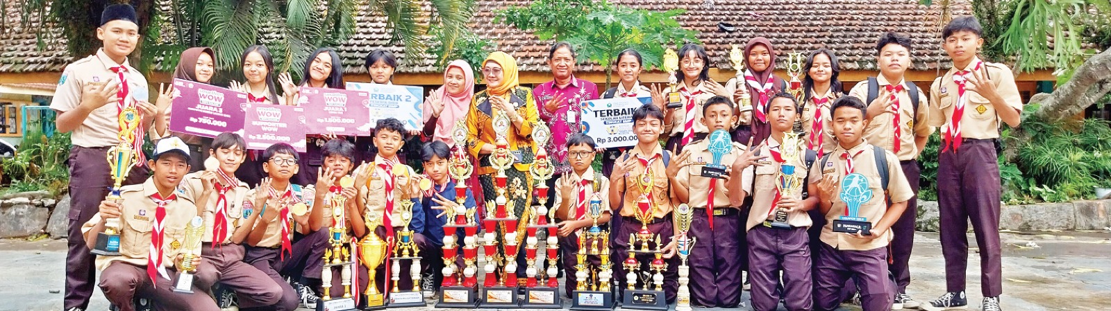 BERTABUR PRESTASI: Kepala SMPN 4 Malang Dr Pancayani Dinihari (tengah) bersama para siswa berprestasi memamerkan piala dan piagam yang diraih. SMPN 4 MALANG FOR RADAR MALANG
