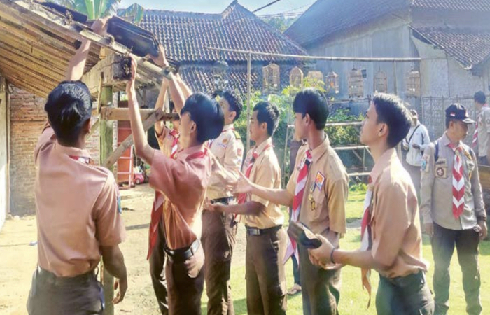 PEDULI SESAMA: Anggota Pramuka Penegak Kwarcab Kota Malang melakukan bedah rumah di Kelurahan Wonokoyo, Kecamatan Kedungkandang, Jumat (25/11).