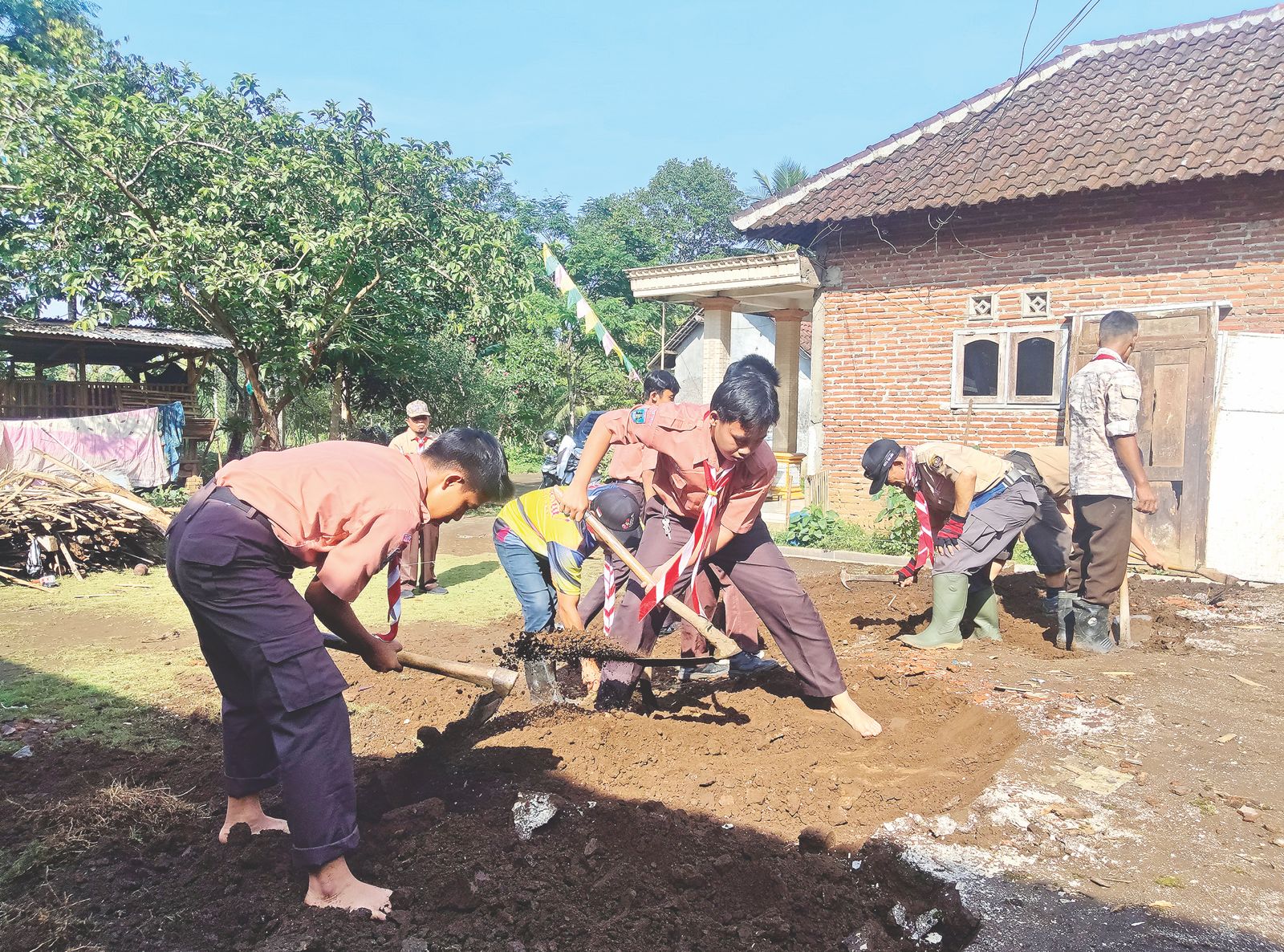 GOTONG ROYONG: Anggota Pramuka Penegak Kwarcab Kota Malang menggali tanah untuk membangun fondasi rumah.