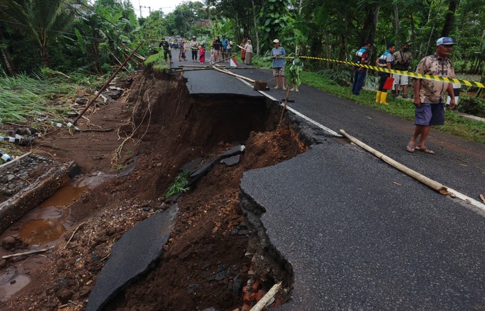 DIAMANKAN WARGA: Separo Jalan Raya Rejoyoso, Kecamatan Bantur, Kabupaten Malang ambrol setelah volume air sungai naik sejak Kamis (28/11).
