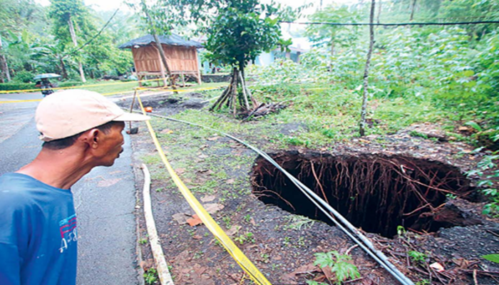 DAPAT PERHATIAN: Tanah di jalur menuju sumber Umbulan Sengkaring, Desa Tulung Rejo, Kecamatan Donomulyo ambles, kemarin  siang (30/11). Foto kanan, petugas meninjau lokasi banjir di Kampung Raas.