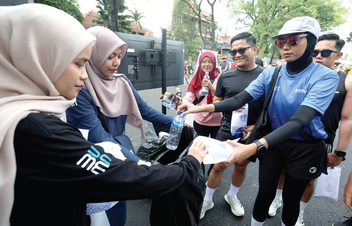 PEDULI LINGKUNGAN: Pengunjung CFD mengumpulkan botol plastik ke dalam kantong kresek untuk didaur ulang menjadi barang reusable kemarin.