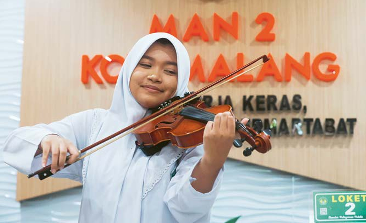 BERBAKAT: Salsabhila Adelia Alika Fitri menunjukkan kepiawaiannya memainkan biola di sekolahnya, kemarin. Dia belajar memainkan biola sejak usia enam tahun. DARMONO/ RADAR MALANG