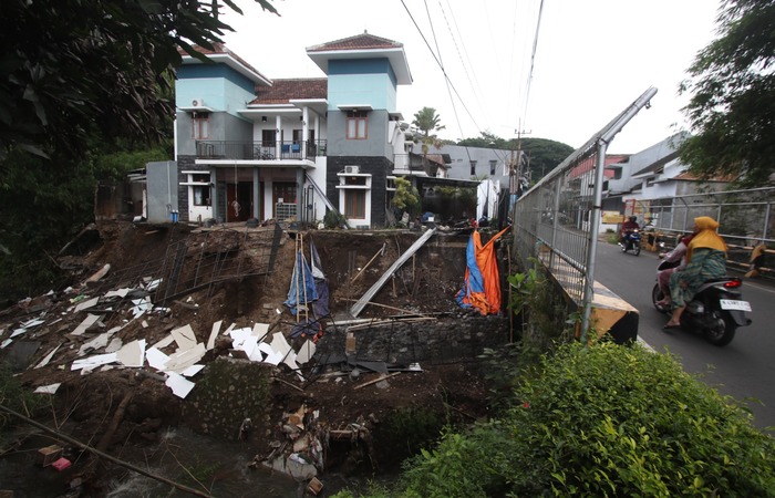 LONGSOR KEDUA: Tebing Kali Bango setinggi 7 meter di Jalan Memberamo, RT 1/RW 14, Kelurahan Bunulrejo, Kecamatan Blimbing, kembali longsor kemarin. emilik rumah di lokasi itu sudah mengungsi