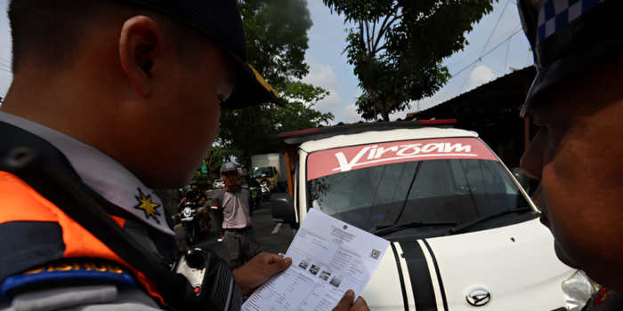 WAJIB TERTIB: Petugas dishub memeriksa dokumen uji kir salah satu pengemudi angkutan barang di Jalan Ki Ageng Gribig, Kelurahan Madyopuro, Kecamatan Kedungkandang, kemarin (5/12).
