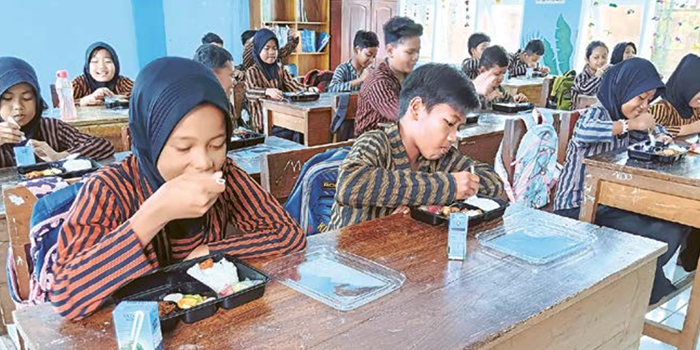 DEMI KUALITAS PENDIDIKAN: Siswa-siswi SDN Penarukan Kepanjen menikmati makan siang gratis kemarin (5/12). Hingga akhir Desember depan, masih ada empat sekolah lagi yang dijadikan lokasi uji coba.