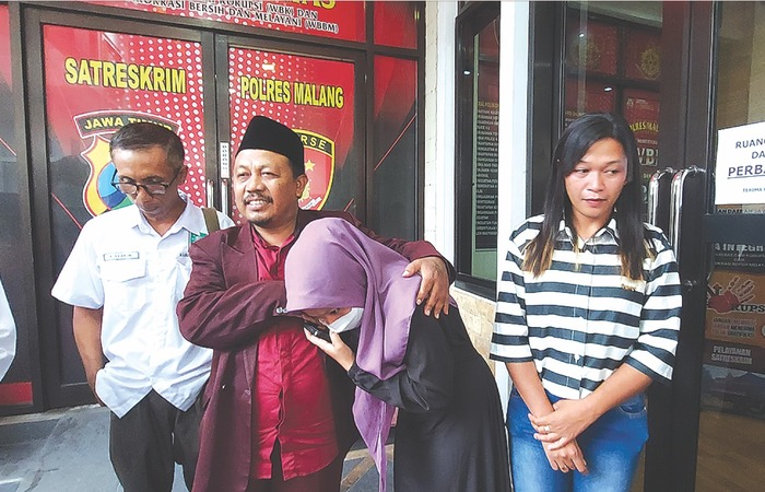 KEKELUARGAAN: Siswi berinisial DE,14, menyalami gurunya, Rupian, 39, setelah keduanya menyepakati damai di ruang Satreskrim Polres Malang kemarin (6/12).
