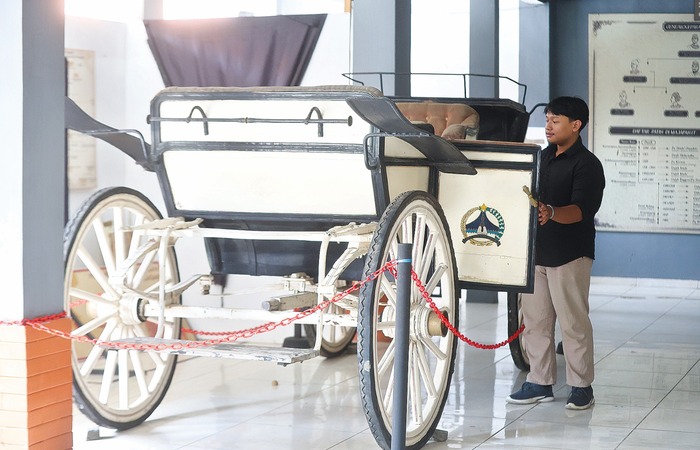 KOLEKSI BARU: Seorang pengunjung Museum Singhasari mengamati kereta kencana era bupati Malang pertama. Kereta tersebut sebelumnya berada di depan kantor bupati
