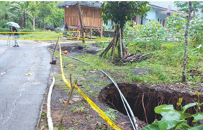 IMBAS BENCANA: Ruas jalan yang berlubang masih terpasang police line kemarin (8/12). Warga dilarang memasuki area tersebut karena khawatir terjadi ambles susulan.