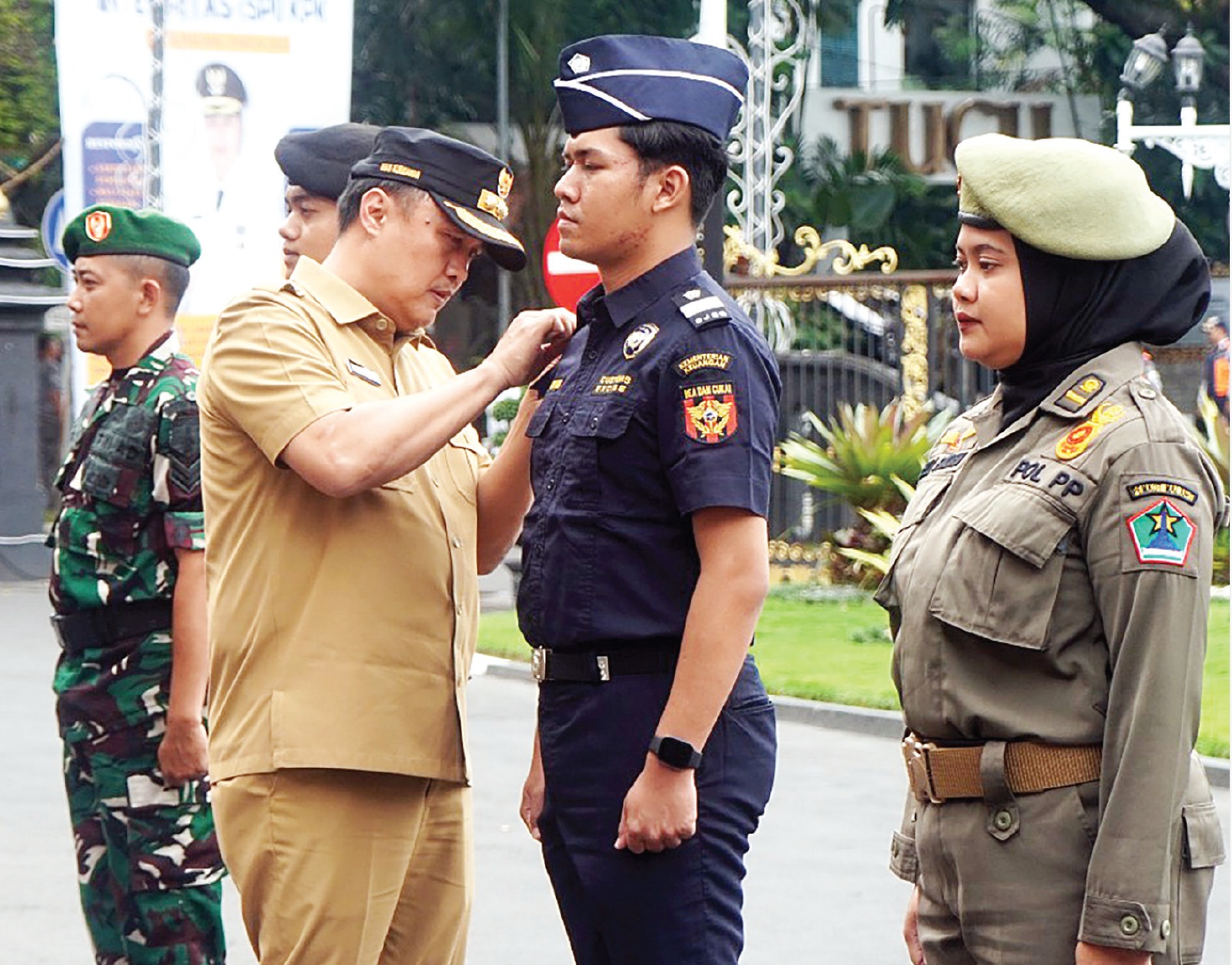 TEGAS: Pj Wali Kota Malang Iwan Kurniawan (kiri) memasang pin kepada aparat penegak hukum yang bertugas untuk menggempur rokok ilegal.