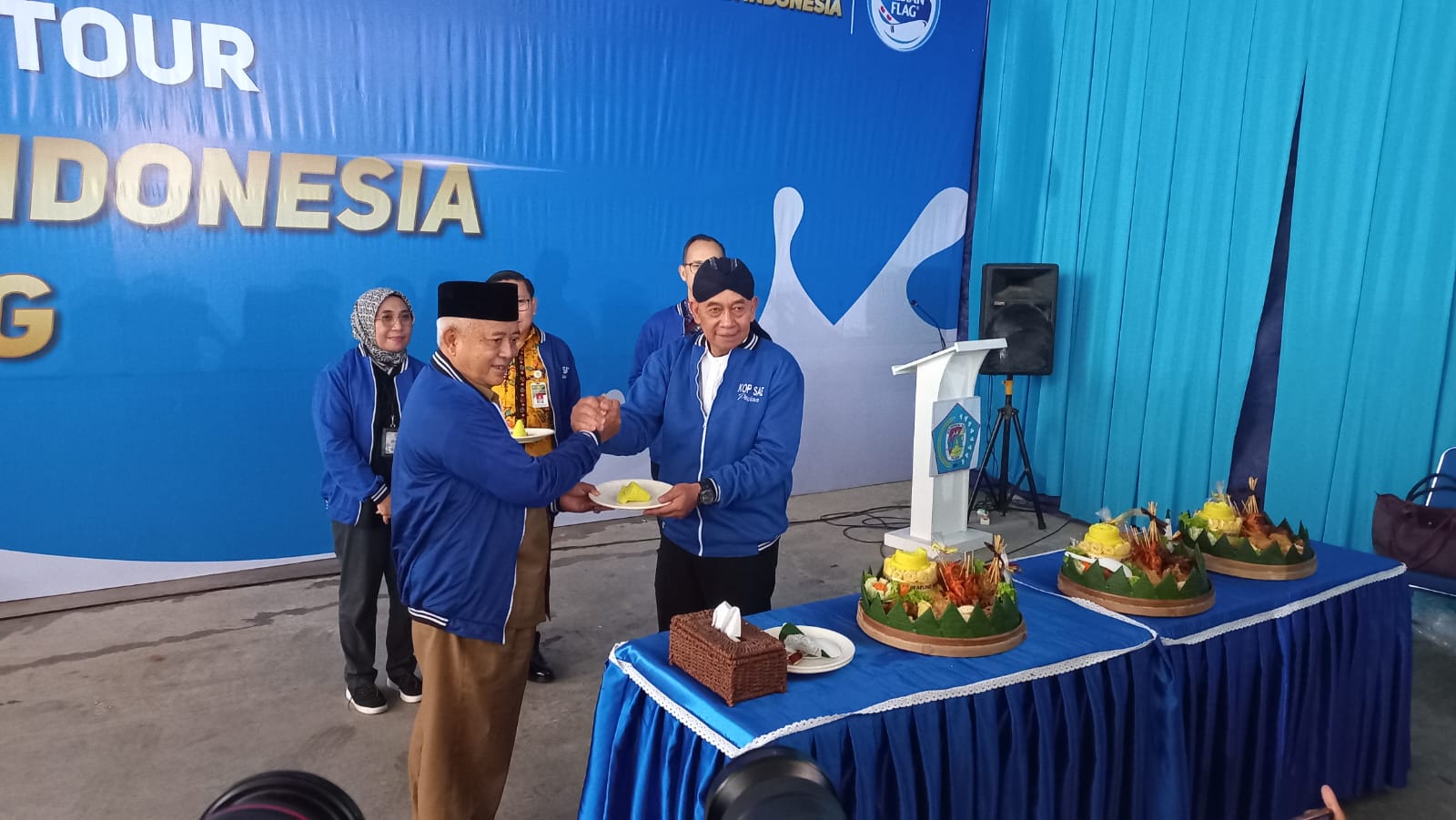 POTONG TUMPENG: Bupati Malang H.M. Sanusi menerima potongan tumpeng dari Ketua Umum Koperasi Susu SAE Pujon H.M. Ni