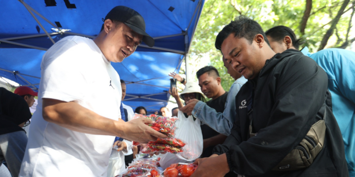 KNDALIKAN HARGA: j Wali Kota Malang Iwan Kurniawan ikut melayani pembeli sayuran di samping Balai Kota Malang pada acara Gerakan angan Murah kemarin.