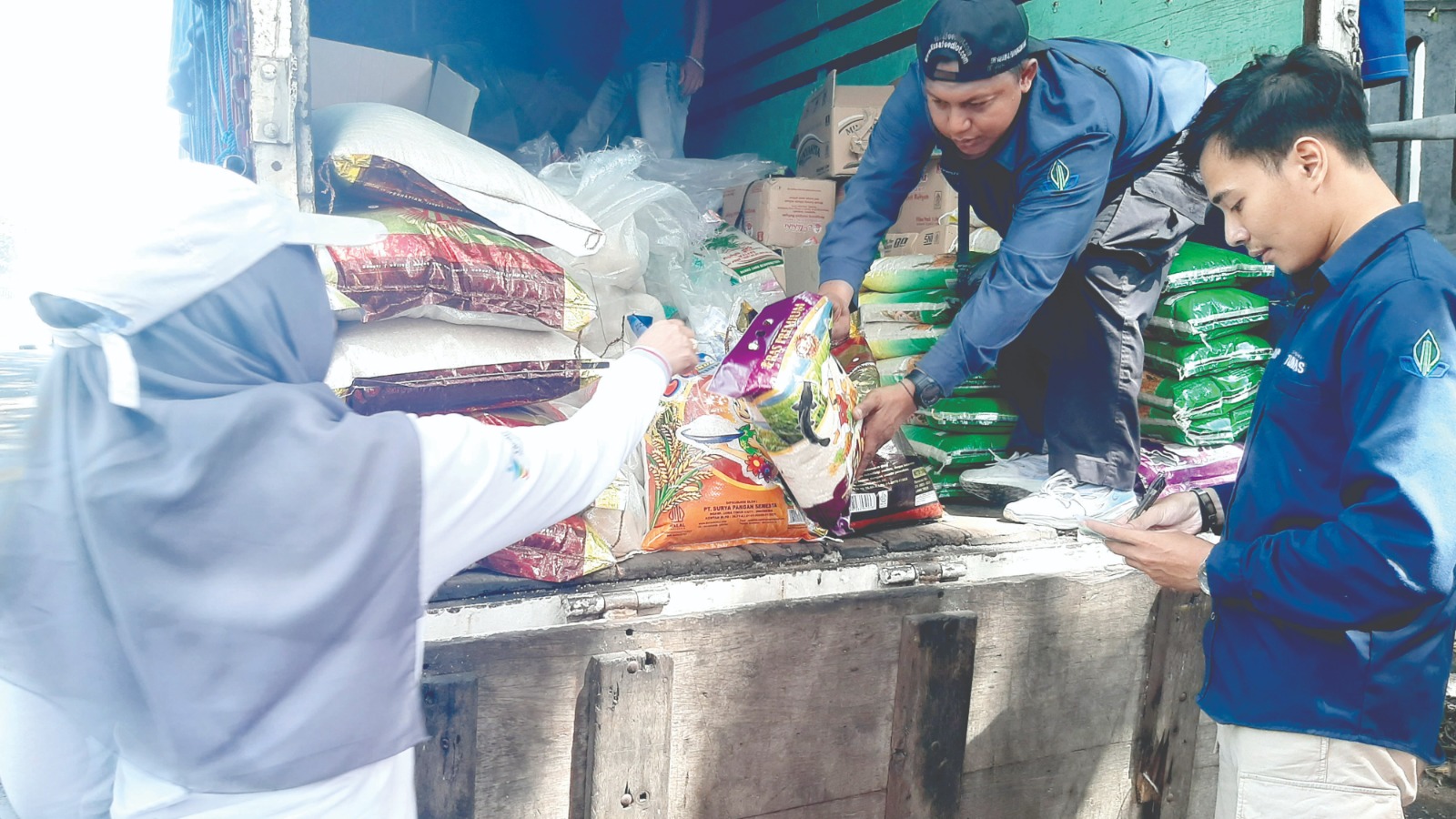 STABILISASI HARGA: Tiga petugas menyiapkan beras yang hendak dijual dalam Gerakan Pangan Murah di samping Balai Kota Malang, Selasa lalu (10/12). DUROTUL KARIMAH / RADAR MALANG