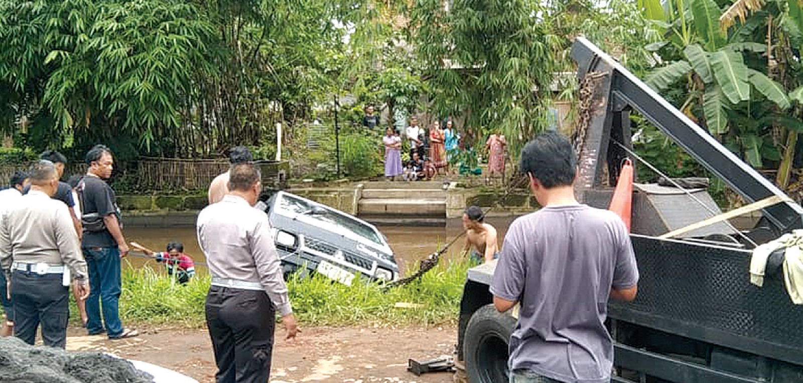 LAKA TUNGGAL: Warga bersama aparat kepolisian mengevakuasi mobil pikap bermuatan pasir yang terperosok sungai di Jalan Penarukan, Kecamatan Kepanjen kemarin (15/12).