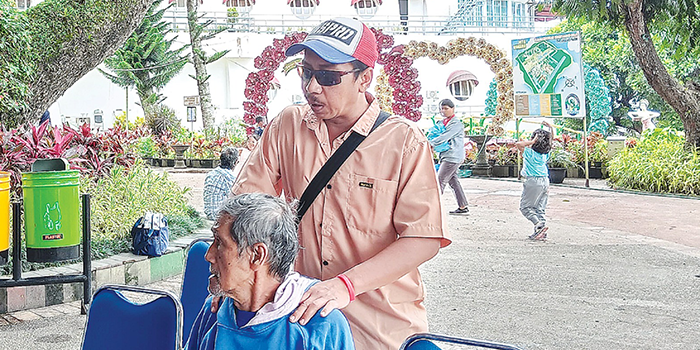 HARI DISABILITAS: Seorang penyandang tunanetra memijat salah satu pengunjung Taman Wisata Sengakling, Desa Sengkaling, Kecamatan Dau, kemarin (15/12).