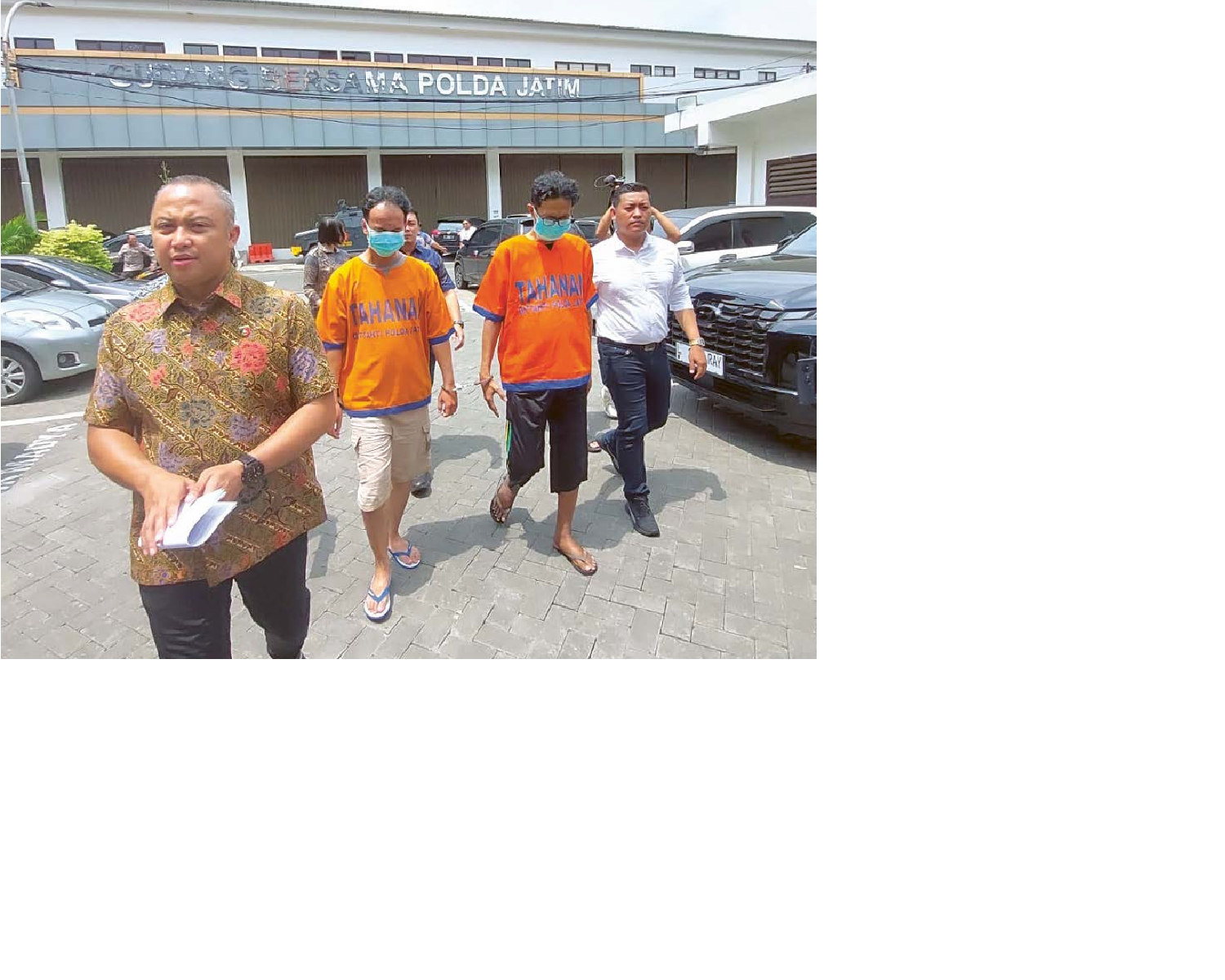 MENUNDUK MALU: Dua pelaku penyebar video syur (baju oranye) digiring ke Mapolda Jatim kemarin siang. DOKUMEN JAWA POS