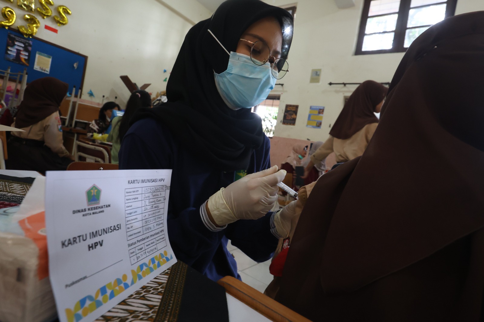 LAUNCHING: Petugas medis menyuntikkan vaksin HPV ke salah  satu siswi di SMP Negeri 3 Malang  kemarin (20/12).