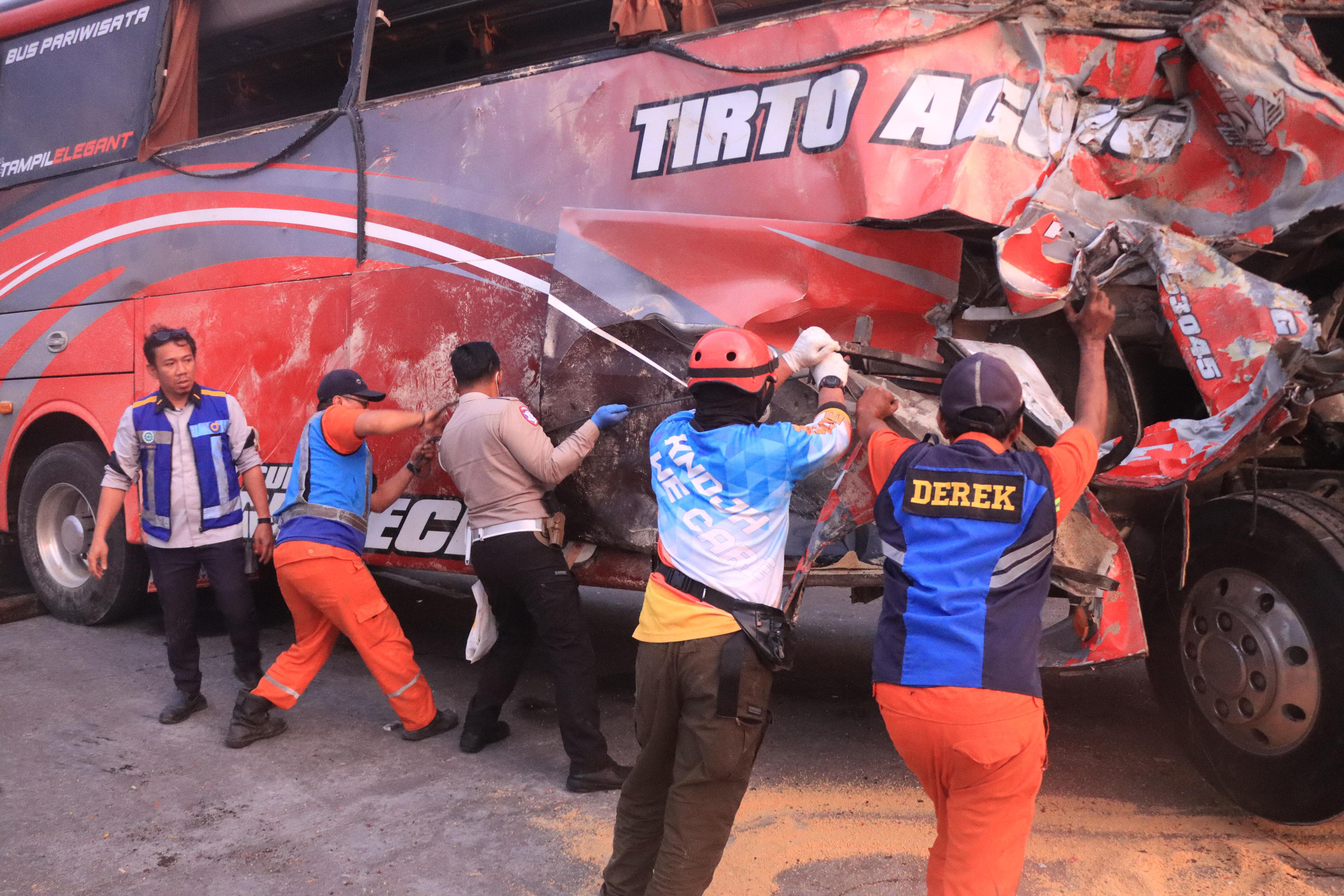 Petugas mengevakuasi bus pariwisata rombongan smp islam terpadu gunung putri bogor yang kecelakaan di tol lawang malang