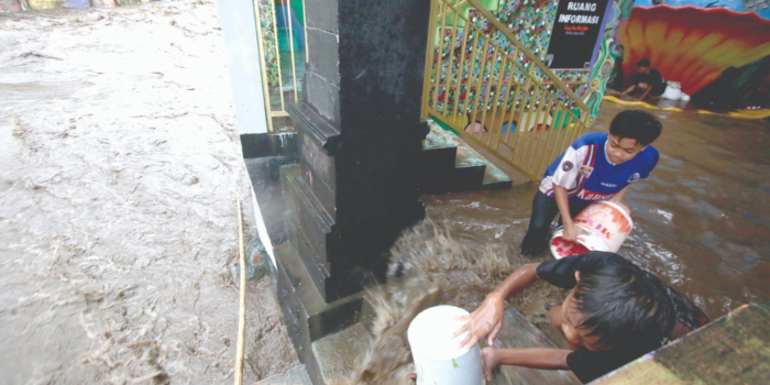 CUKUP PARAH: Warga Kampung Warna-Warni menguras air yang masuk ke rumah kemarin siang.