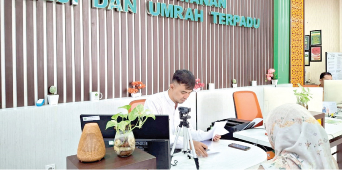 MULAI PERSIAPAN: Staf Kemenag Kota Malang melayani salah satu warga, kemarin. Kemenag sudah menyiapkan sistem pemberangkatan jemaah haji pada 2025