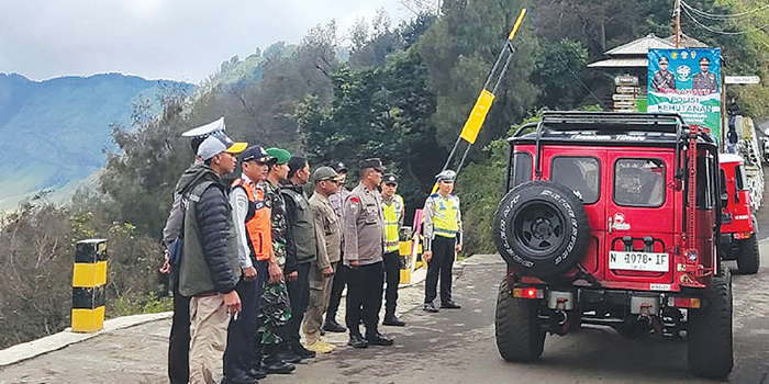 JALUR WISATA: Polisi mengatur beberapa kendaraan wisatawan yang memasuki pos pengamanan (pospam) Jemplang, Desa Ngadas, Kecamatan Poncokusumo, Kabupaten Malang kemarin (27/12).
