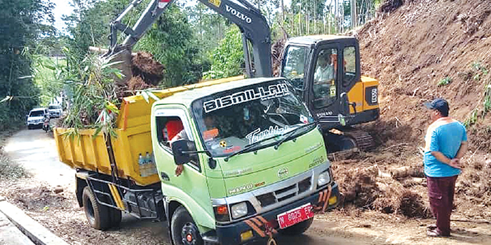 BENCANA: Satu unit alat berat diterjunkan untuk mengevakuasi longsoran tanah di Jalan Raya Duwet Kecamatan Tumpang kemarin (27/12).