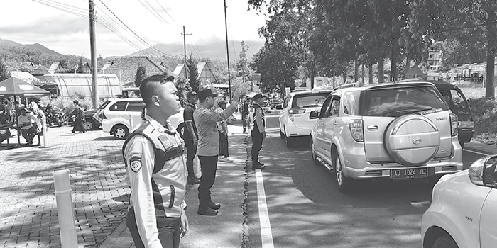 REKAYASA LALIN: Personel dari Dishub Kabupaten Malang dan Polres Batu mengatur kendaraan di jalur Pujon-Batu kemarin (27/12).