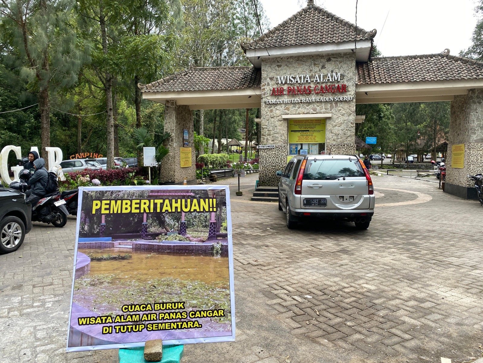 ANTISIPASI: Pihak pengelola pemandian air panas Cangar di Desa Sumberbrantas, Kecamatan Bumiaji, Kota Batu, memasang papan pengumuman tutup sementara tanpa batas waktu.