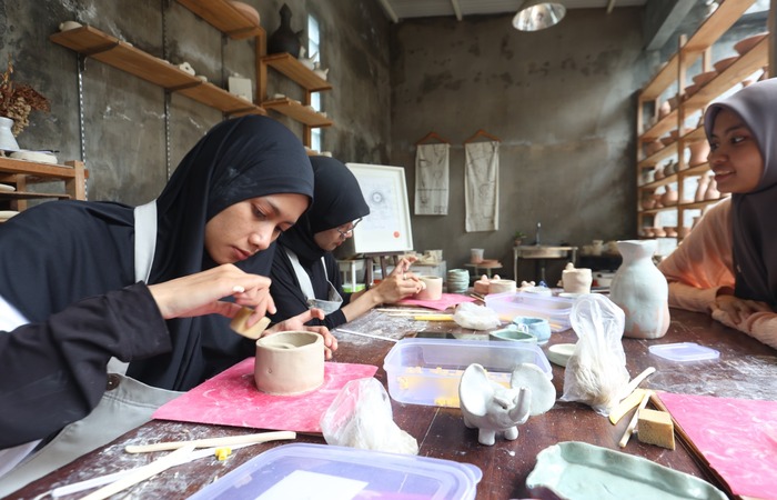 HARUS RESERVASI DULU: dua peserta pelatihan di studio Matahati Ceramics melakukan finishing terhadap produk keramik buatannya.