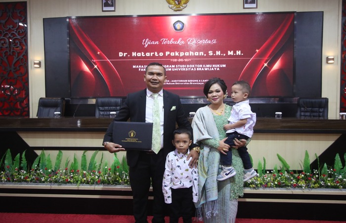LULUS S3: Dosen FH UNMER Malang Dr Hatarto Pakpahan SH MH (kiri) foto bersama istri dan anaknya setelah ujian disertasi kemarin.