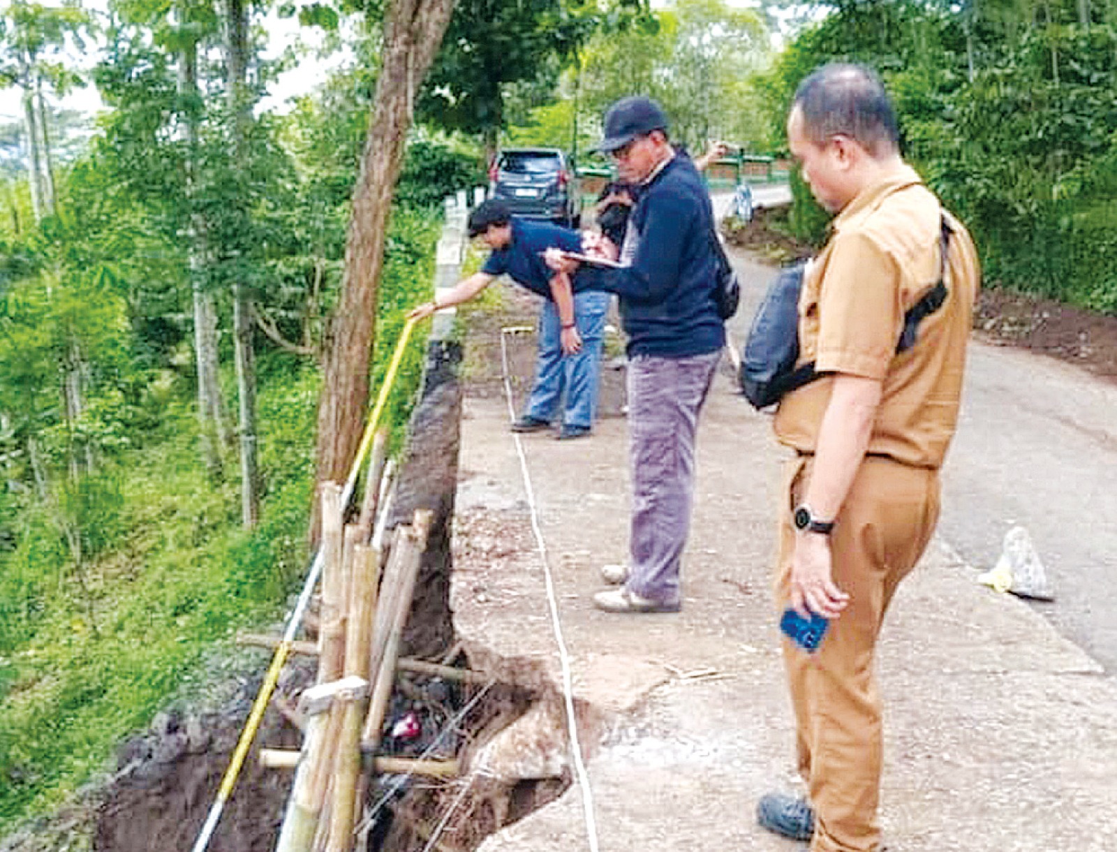 GERAK CEPAT: Tim dari BPBD dan Perangkat Desa meninjau pemasangan bambu penyangga untuk mengantisipasi longsor susulan.