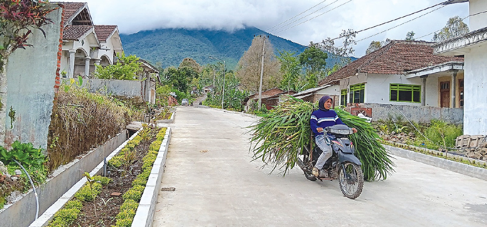 INFRASTRUKTUR: Warga mengendarai  sepeda motor di jalan Desa Balesari,  Kecamatan Ngajum kemarin. Biaya  pembangunan jalan dibantu pengusaha.