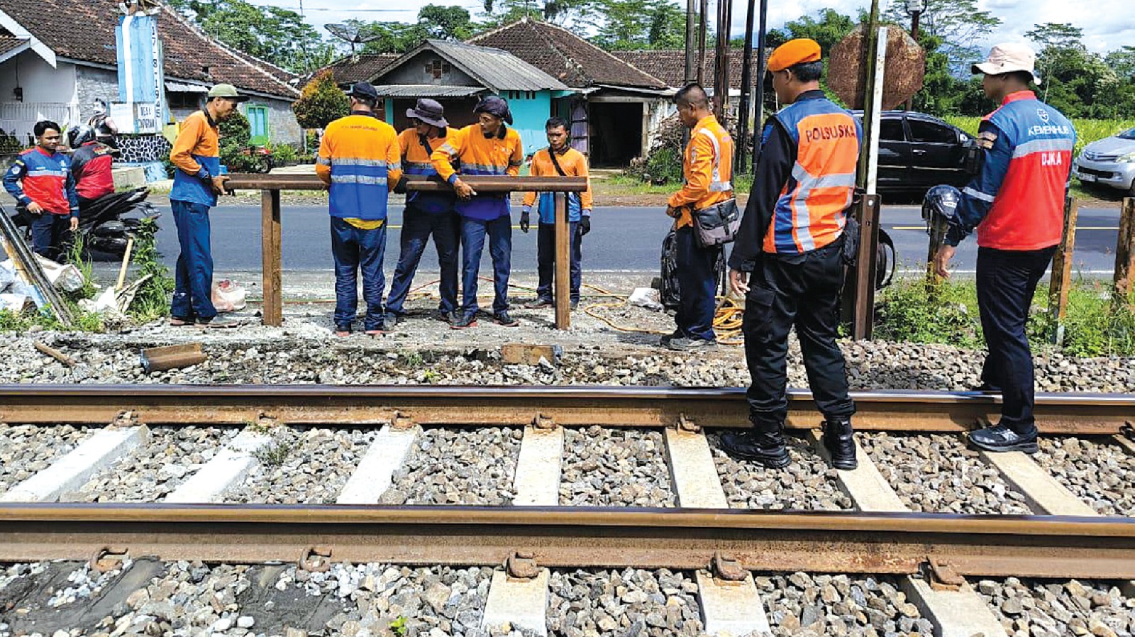PERLINTASAN ILEGAL: Beberapa petugas dari PT KAI Daerah Operasi (daop) 8 Surabaya memasang palang besi di pintu perlintasan Sumberpucung, jumat lalu (3/1).