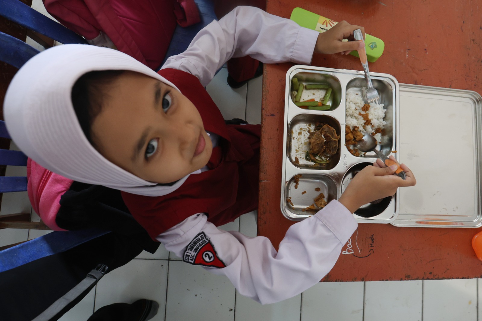 LIMA HARI DALAM SEPEKAN: Siswi SDN 1 Tamanharjo, Kecamatan Singosari, Kabupaten Malang, menikmati menu program Makan Bergizi Gratis (MBG) yang dilaksanakan mulai kemarin (6/1). DARMONO/RADAR MALANG