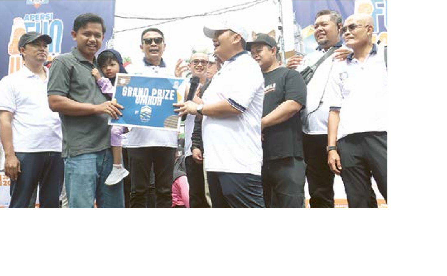 HADIAH UTAMA: Ketua Apersi Malang Raya Doni Ganatha (kanan) menyerahkan hadiah utama umrah kepada Ahmad Khoiruddin