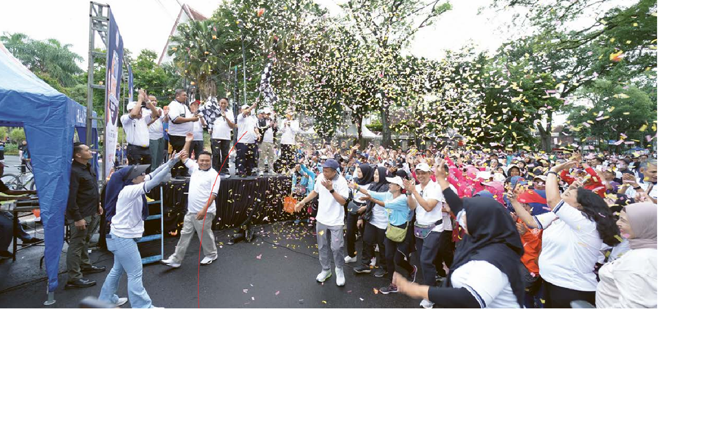 MERIAH: Ketua Apersi Korwil Malang Raya Doni Ganatha didampingi Wali Kota Malang terpilih Wahyu Hidayat mengibarkan bendera tanda dimulainya fun walk, Minggu (5/1). DARMONO/RADAR MALANG