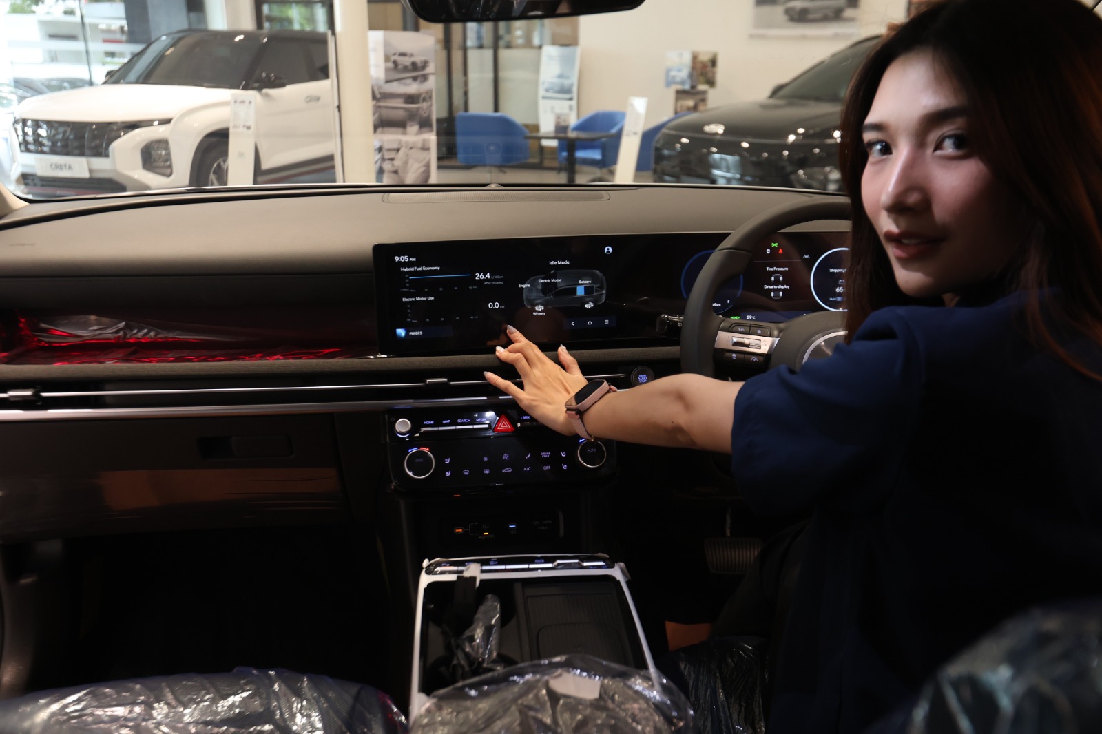BANYAK YANG MENUNGGU: Salah satu sales menunjukkan desain interior mobil hybrid produksi Hyundai, kemarin. Tahun ini, kabarnya ada insentif untuk penjualan mobil hybrid dan listrik.