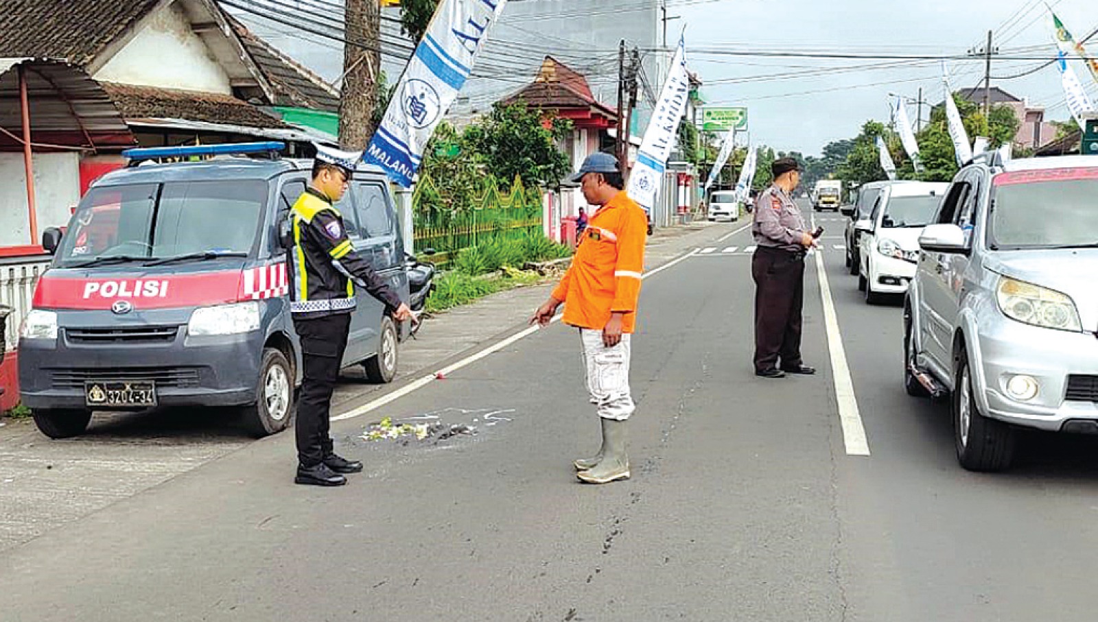 LAKA MAUT: Aparat kepolisian mengatur arus lalu lintas di Jalan Raya Gading, Kecamatan Bululawang kemarin (6/1). SATLANTAS POLRES MALANG FOR RADAR KANJURUHAN