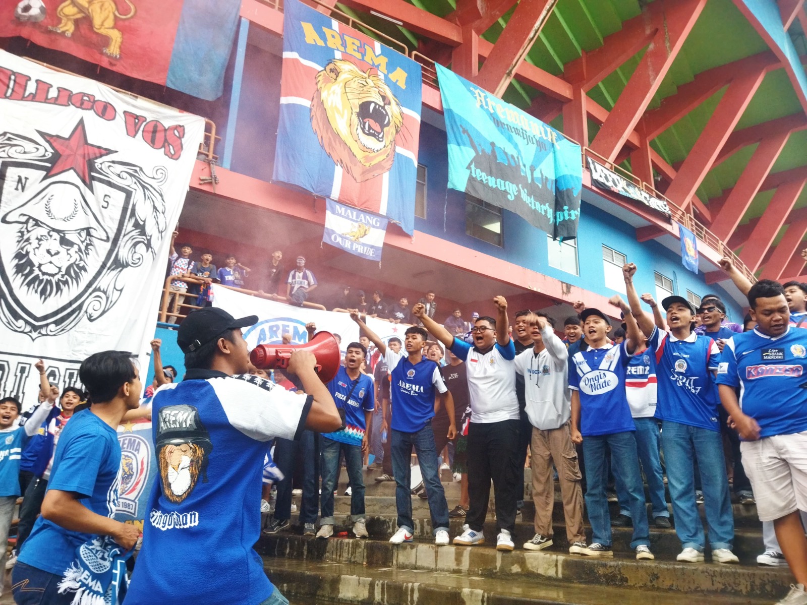 SETIA: Para pendukung Arema Indonesia menyanyikan chant bersama di depan Stadion Gajayana, Senin lalu (6/1). GRATIO IGNATIUS S.B. / RADAR MALANG