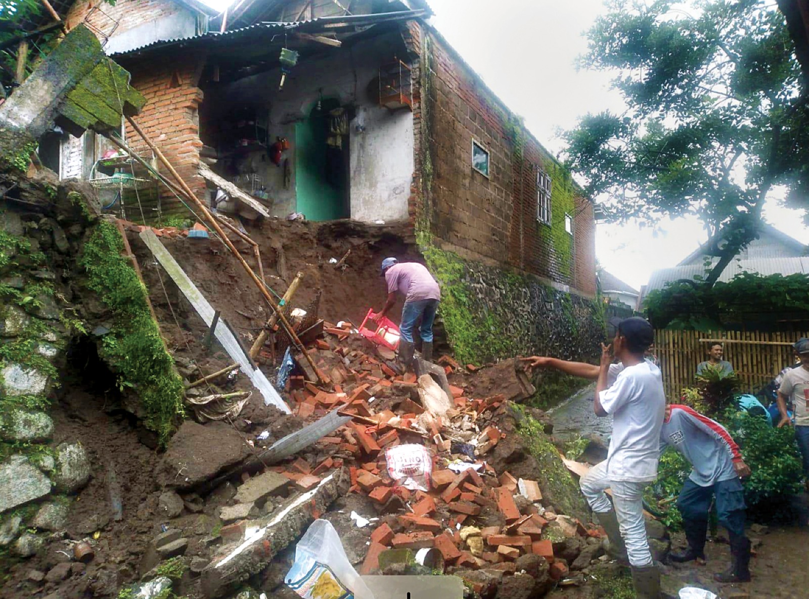 SETELAH HUJAN DERAS: Tembok belakang rumah milik salah seorang warga di Dusun Suwaru, Desa Duwet, Kecamatan Tumpang, roboh akibat plengsengan di bawahnya longsor kemarin (8/1).