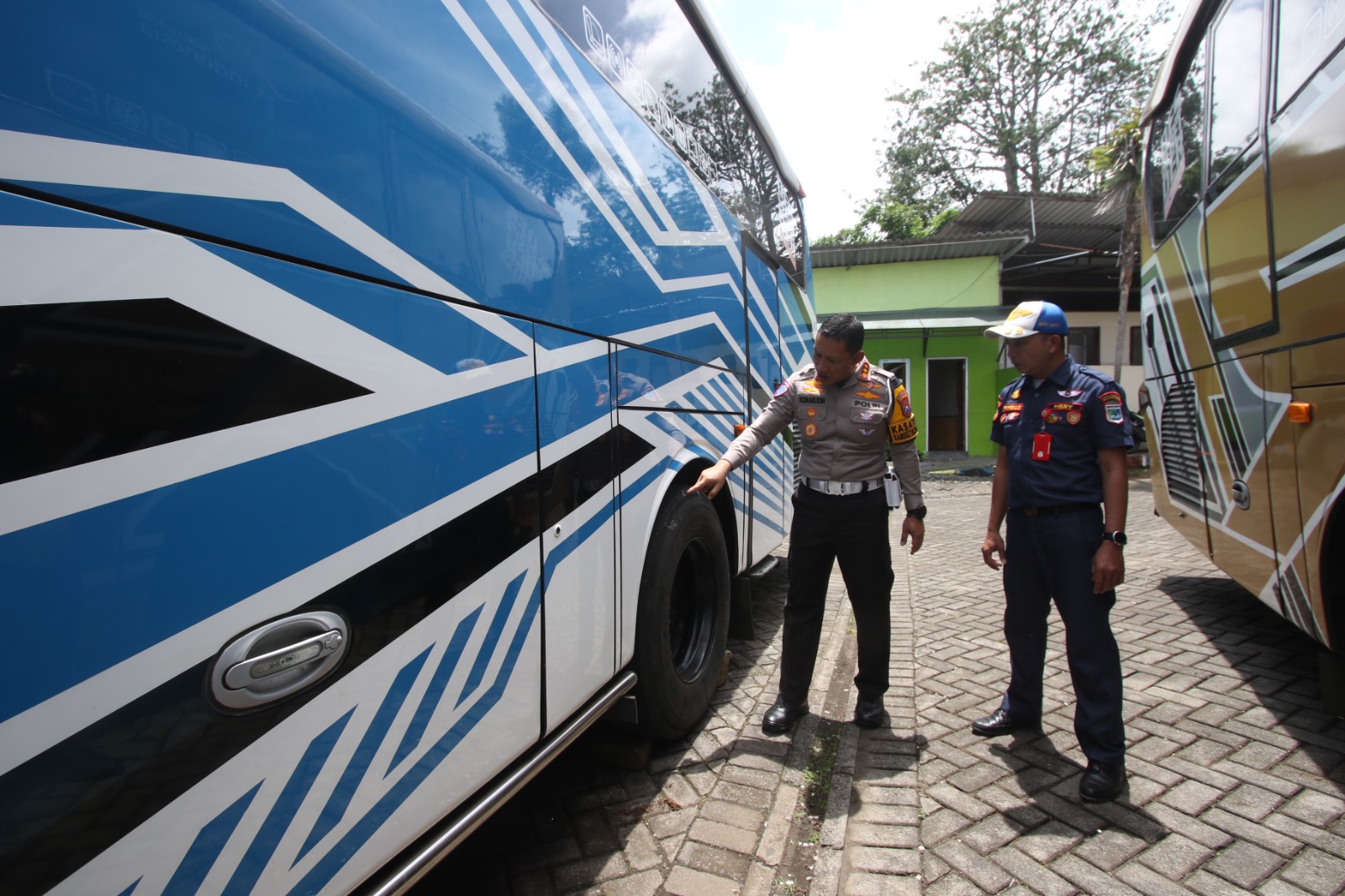 RAMP CHECK: Petugas memeriksa kondisi ban salah satu bus yang digunakan rombongan SMK TI Bali Global kemarin (9/1). SATRIA CAHYONO/RADAR MALANG