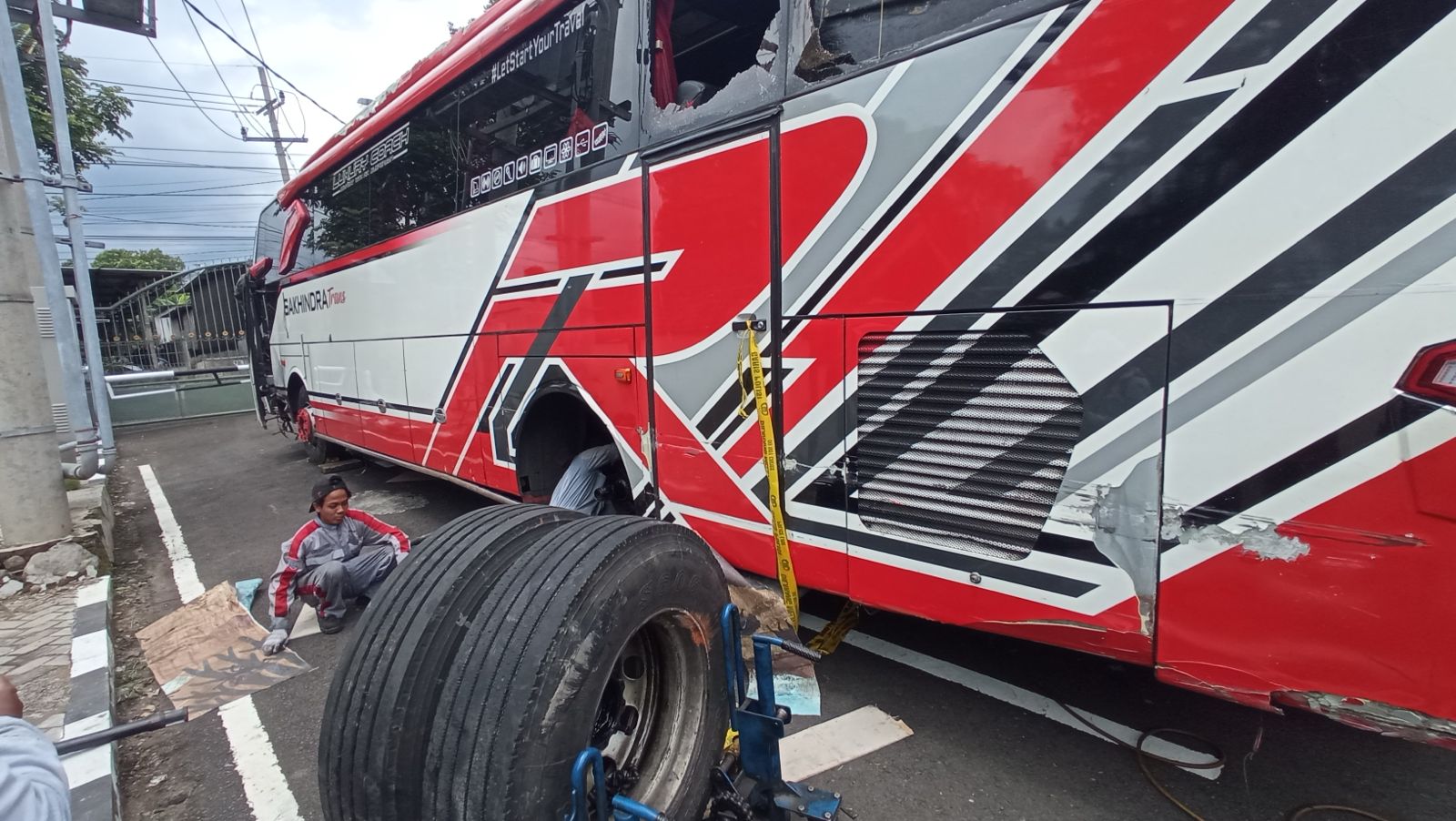 Teknisi melepas roda belakang bus Sakhindra Trans untuk kepentingan pemeriksaan sistem pengereman di halaman Mapolresta Batu kemarin (10/1). Pemeriksaan dilakukan tim KNKT